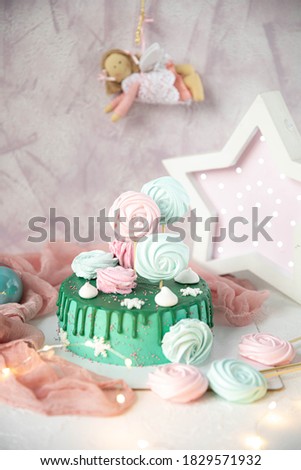 Delicious Princess cake decorated with pink and white meringues on a pink background and a white shining star