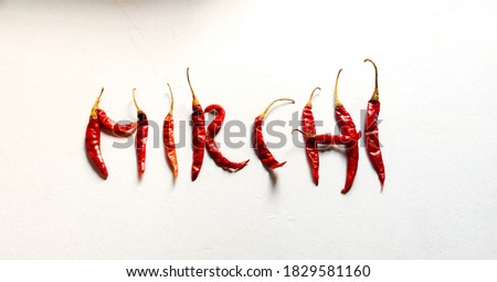 A picture of red chilies with white background likes written "Mirchi" in Hindi. Food Stock Photography.