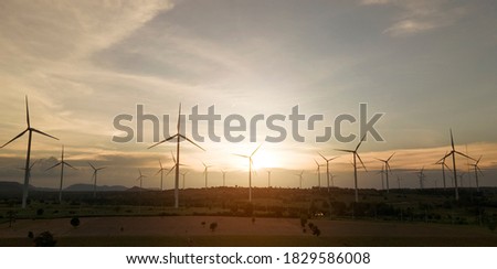 wind turbines plant for electric power production silhouette at sunset ,clean energy concept