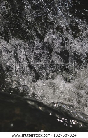 A black and white vertical shot of waterfall and splashing stream - perfect for background