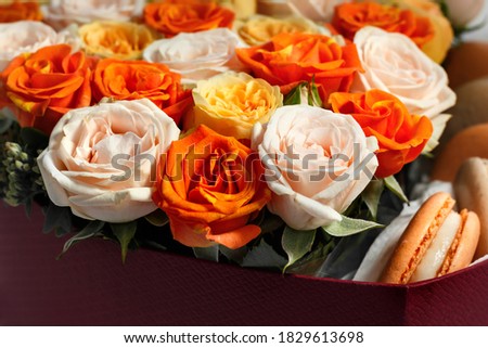 Bush rose in a box, with Macaroons, close-up with a blurry background, as a birthday gift, partial sharpness
