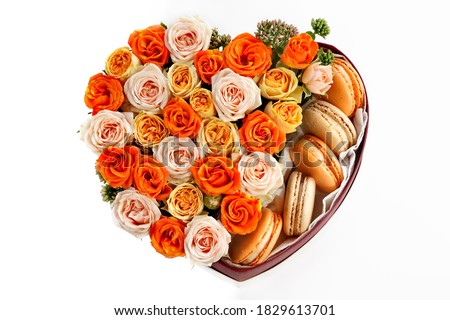 beautiful bright heart-shaped box with flowers and sweets, on a white background, Bush rose, close-up with a blurred background, autumn color scheme, top view