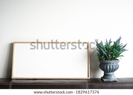 Blank picture frame and fake tree, copy space for text.
