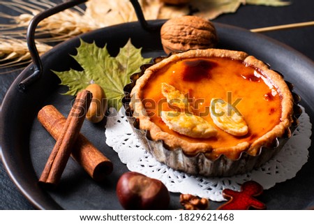 Autumn food concept homemade organic rustic Pumpkins pie decorate by autumn leave on black background with copy space