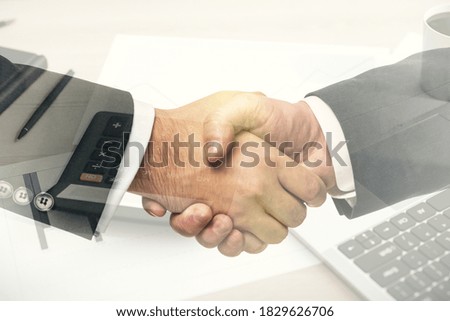 Double exposure of handshake two businessmen and calculator on the table on background, research and strategy concept