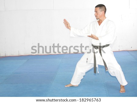 Black belt Man in kimono during training karate kata exercises