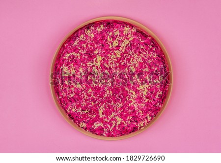 traditional Russian holiday salad Herring under a fur coat (shuba)  on a pink background top view