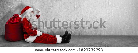 Sitting Santa Claus With A Bag. Christmas and New Year Concept