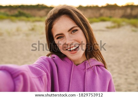 Young caucasian beautiful woman smiling and taking selfie photo while walking outdoors