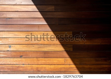 Natural wooden surface background and texture with a half in sunlight and a half in shadow.