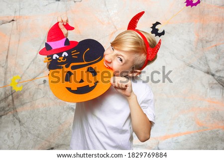 a child with a pumpkin on Halloween