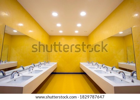 Empty school sink with yellow walls designed for children Royalty-Free Stock Photo #1829787647