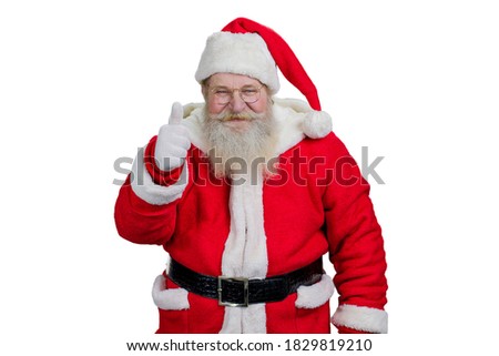 Studio shot of smiling Santa Claus. Portrait of Santa Claus giving thumb up on white background.