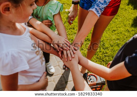 Young friends hands grouped together while birthday party game. View from above.