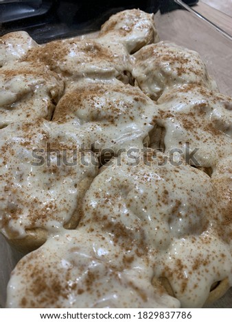 Freshly baked cinnabon buns or cinnamon rolls with cream sauce. Traditional homemade sweet buns. Autumn concept.