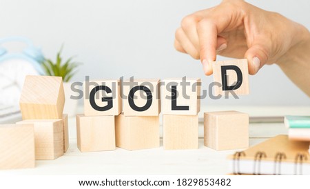 business man Hand change wood cube block with GOLD text to UP and Down arrow symbol icon. Interest rate, stocks, financial, cut loss and economic concept