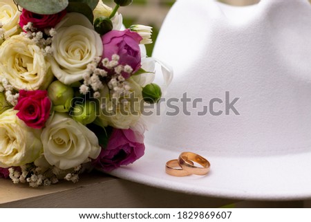 wedding rings on a white stylish hat next to the bride's bouquet. marriage concept.