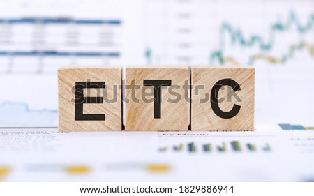 Alphabet letter in word ETC (abbreviation of et cetera) on financial graphs background Royalty-Free Stock Photo #1829886944