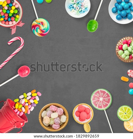 Candies, chocolates and lollipops on a gray background with copy space. Backdrop, banner o background with sweets. Top view of colorful sweets. Copy space.