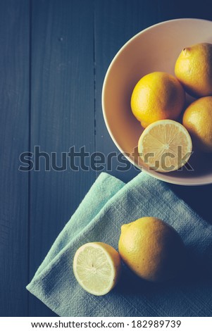 Sliced and whole lemons on wooden table