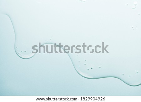 Cream gel gray blue transparent cosmetic sample texture with bubbles blue mirror background