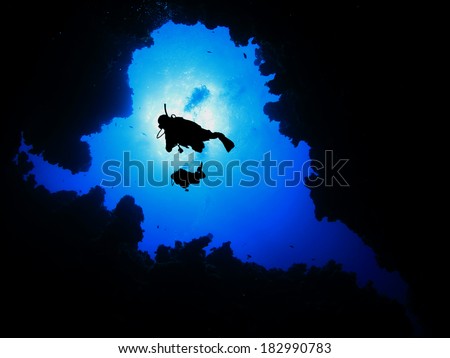 Two Scuba Divers descending into underwater cave Royalty-Free Stock Photo #182990783