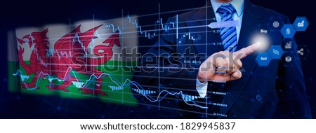 Businessman touching data analytics process system with KPI financial charts, dashboard of stock and marketing on virtual interface. With Wales flag in background.