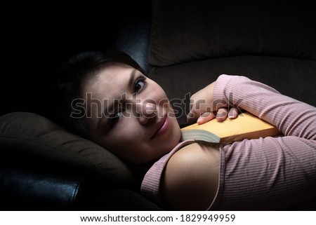woman reading a book on a sofa