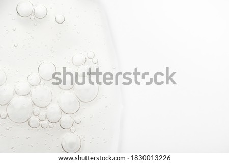 Sample of the texture of liquid hyaluronic gel for face care on white background. Cosmetic moisturizing beauty product for gentle cleansing of female skin with acids. Smeared transparent bubble serum Royalty-Free Stock Photo #1830013226