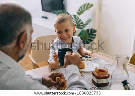 grandfather and grandson having breakfast at home