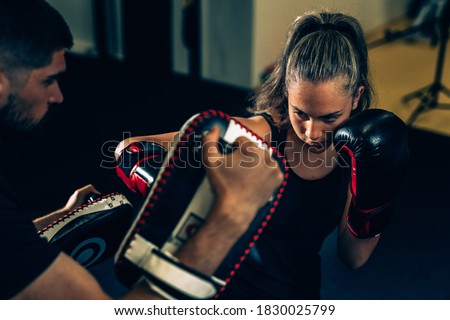 woman practice boxing with her personal trainer