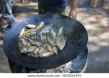 The process of frying fish over a fire after fishing. Selective focus with blurred background