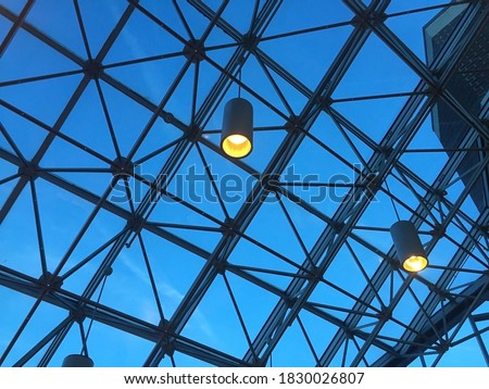 Industrial skylight under a dark blue early morning sky with two lighting fixtures Royalty-Free Stock Photo #1830026807