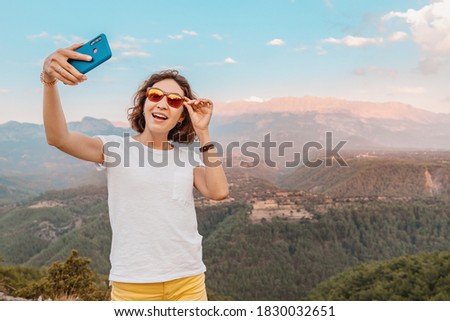 female travel blogger and social media influencer takes photos against the backdrop of the Taurus mountains in Turkey