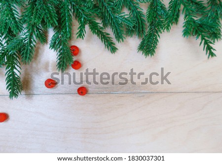  Wooden background with fir branches and berries of mountain ash.                              
