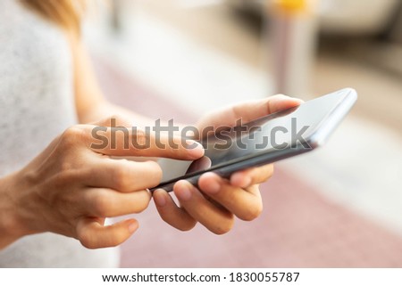 woman using smart phone for shopping online on outdoor park street background.