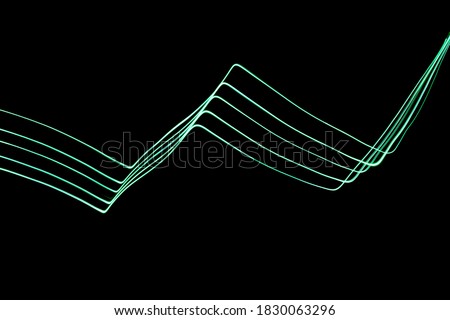 Long exposure photograph of neon green colour in an abstract geometric chevron, parallel lines pattern against a black background. Light painting photography.