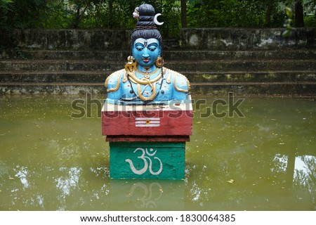 Lord shiva idol in a pond, front view.