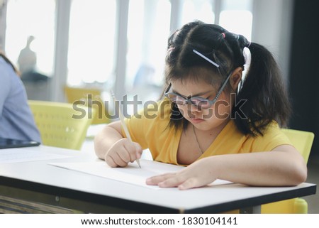 Disabled kids classroom, down syndrome children try to focus on lesson during study at school, kids learning together, schoolgirls studding in classroom