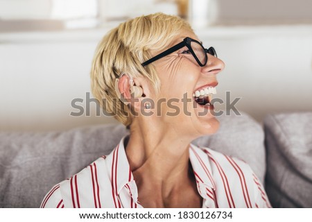 Mature woman with hearing aid indoors smiling Royalty-Free Stock Photo #1830126734