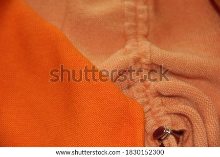 Bright orange cotton fabric. Creases on the fabric. Backgrounds