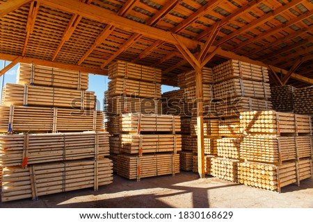 Piles of wooden boards in the sawmill, planking. Warehouse for sawing boards on a sawmill outdoors. Wood timber stack of wooden blanks construction material. Lumber Industry.