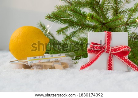 Medical bath, gift box, thermometer and Christmas tree on a snowy background. Copyspace. Medication. Catarrhal disease. Limon.
