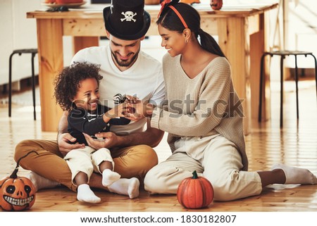 happy multiethnic family mother, father and little son have fun and celebrate Halloween at home
