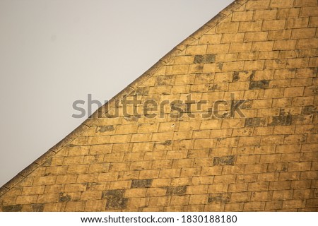 Terra cotta texture on the diagonal edge of a dome against the sky