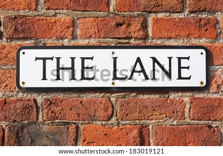 Road Sign on a brick wall reading  "The Lane."