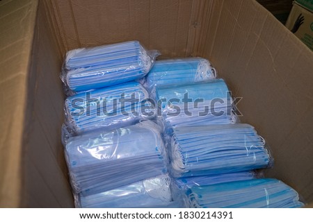 Medical surgical face mask inside boxes on wooden background. View from above
