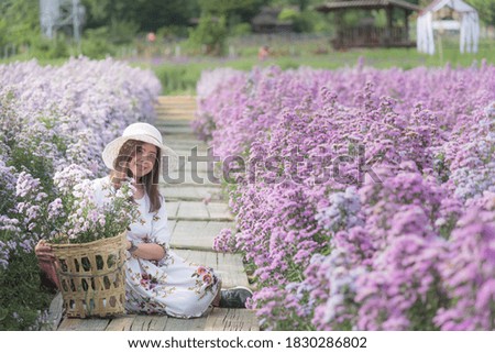 Pretty asian woman enjoying beautiful flowers at flower garden in chiang mai Thailand.