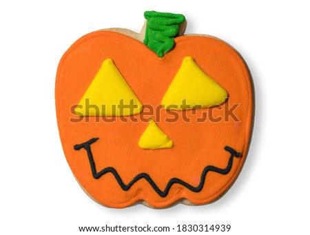 Hand crafted cookie on halloween.  Pumpkin Jack-o-lantern cookie candy. Trick or treat Happy Halloween. Isolated on white background.