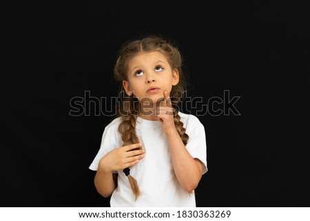 A little girl posing on a black background.